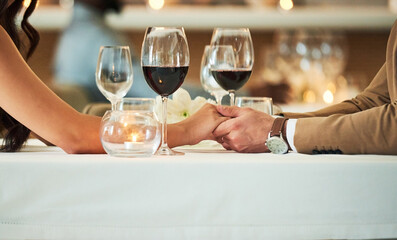Love, wine and couple holding hands in restaurant for romantic dinner, date and anniversary celebration. Relationship, fine dining and man and woman together for luxury date, alcohol and honeymoon