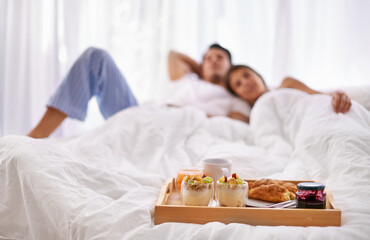 Breakfast food, bed and couple in a bedroom at home with blurred background. Fruit, house and relax...
