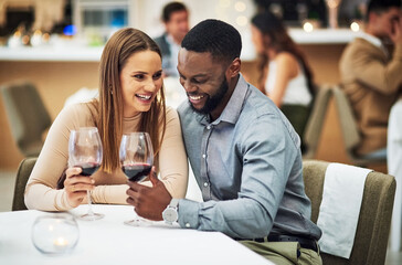 Cheers, love and couple on a date in a restaurant for valentines day, romantic event or anniversary. Happy, smile and interracial man and woman drinking wine, talking and bonding at a luxury dinner.