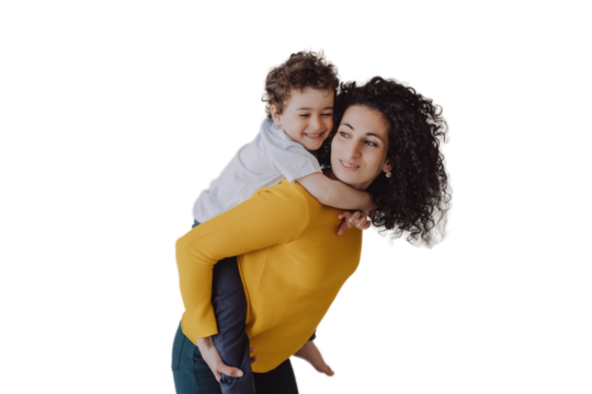 Young smiley curly woman having fun with son, rolls him on back smiling wide. Babysitter in yellow sweater, green pants entertains little cheerful child against transparent background. sister, brother