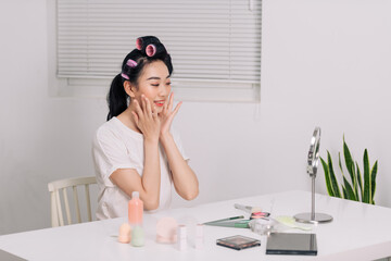 Close up smiling young woman wearing white t-shirt doing facial massage