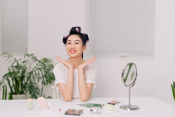 Obraz premium Close up smiling young woman wearing white t-shirt doing facial massage