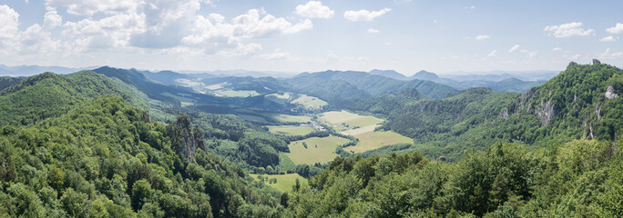 Naklejka na ściany i meble Panoramic view on green valley surrounded by lush forest and mountains, EU, Slovakia
