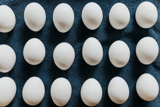 Close up of fresh store bought white eggs on blue kitchen towel