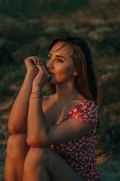 woman close-up summer sitting on the grass darting look