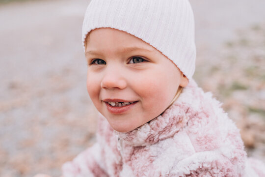 Toothless baby girl blonde caucasian in a hat smiling