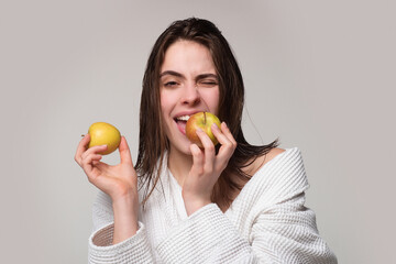 Stomatology concept. Fruits diet. Girl eat apple. Portrait of young woman eating apple isolated over gray background. Healthy diet fruits. Dieting or dental health care.