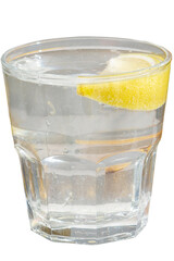 Clear water with lemon in a glass. Cocktail with a clear drink and a slice of lemon. Lemonade with lemon