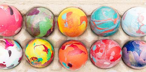 Composition de Pâques avec des œufs de poules colorés rangés dans une boite à œufs. Concept de fêtes de Pâques. Vue de dessus.