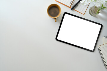 Modern workplace wot digital tablet, cup of coffee and notepad on white table. Flat lay, Top view