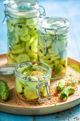 Homemade canned cucumber in jar with herbs