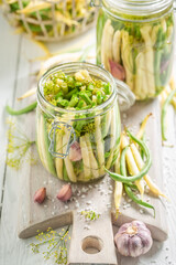 Healthy canned yellow and green beans in jar with herbs.