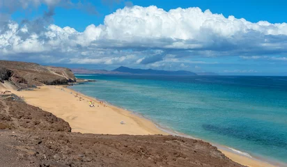 Papier Peint photo Plage de Sotavento, Fuerteventura, Îles Canaries Vista panorámica de la playa de arena blanca llena de gente, mar turquesa de Jandia desde el acantilado, rodeada de un paisaje volcánico y desértico en la de Fuerteventura en las Islas Canarias