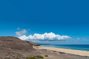 Vista panorámica de la impresionante playa de Jandia en Fuerteventura con arena blanca, mar turquesa, rodeada de un paisaje volcánico y rocoso en la costa de las islas Canaria