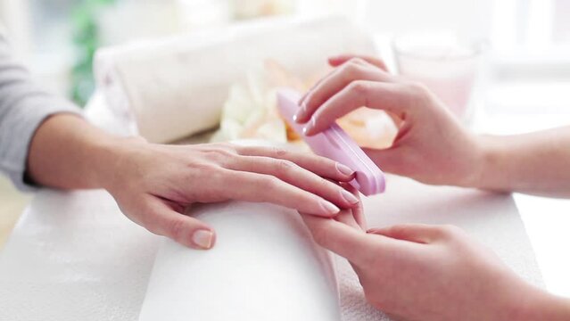 Woman having her nails manicured at a beauty salon.