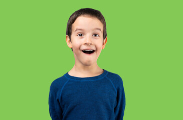 Dark haired little child making listen gesture with shocked face, looking skeptical and sarcastic,...