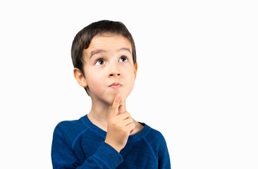 Pensive child looks away at copy space thinking isolated on a white background, funny kid lips hold...