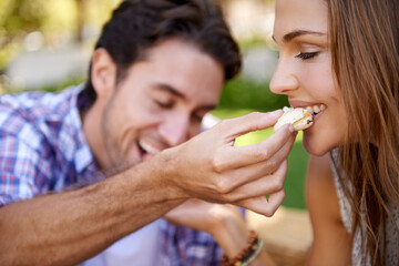 Couple picnic, romantic and feeding on grass lawn with happiness, kindness and love on valentines...