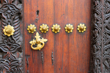 Traditional arab zanzibar wooden door and doorway ornately carved and decorated with brass fittings