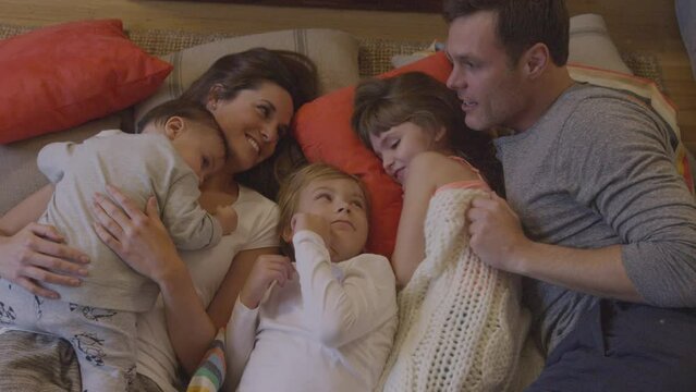 Family in bed including mom, dad and the kids