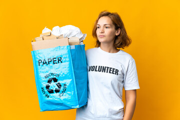 Young Georgian girl holding a recycling bag full of paper to recycle looking to the side