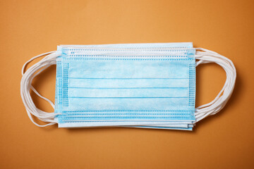 Surgical masks on an orange table.