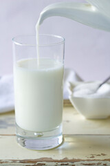 A milk jug filling a glass.