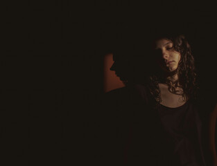young woman on black background with light and shadow on face