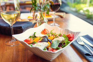 Salad with glass of white wine on table restaurant
