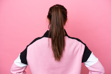Young sport Brazilian woman isolated on pink background in back position