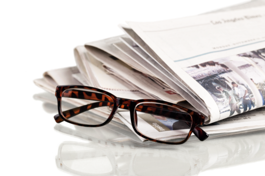 Closeup of Newspapers with Eyeglasses