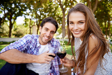 Couple portrait, wine or love toast on picnic date, valentines day or romance bonding in nature park or garden. Smile, happy woman or man and alcohol drinks glass for marriage anniversary celebration