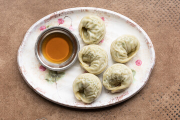 There are dumplings and soy sauce on the plate