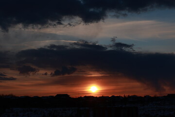 A beautiful sunset with clouds above the village.