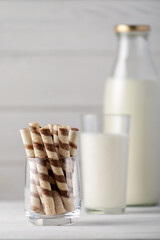 Sweet rolls with fresh milk on a white wooden background.