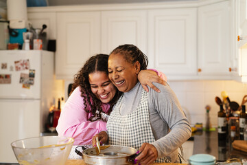 Happy African mother and daughter preparing a homemade dessert - 568013800
