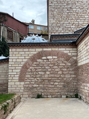 Exterior view of an ancient arabic ottoman turkish bath hammam with red brick walls and domes with traditional round glassed window holes called elephant eyes.