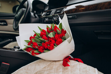 Bouquet of red tulips lying in car