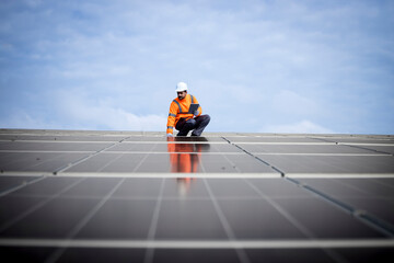 Solar energy worker or engineer with his laptop computer checking installation and productivity of...