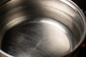 Water in a pot is on the stove in the kitchen. Preparation for boiling water.