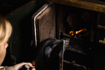 bellows for kindling the fireplace. A woman is lighting a stove.
