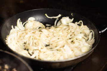 Roasting onions. Chopped onions are fried in a pan. Cooking food.