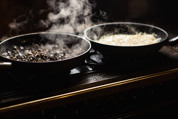 Frying mushrooms in a pan. Finely chopped champignons are cooked. Steam is coming.