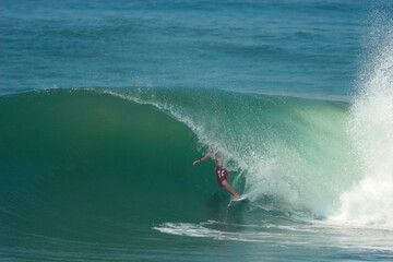 Obraz premium A surfer rides a perfect tube on a wave in the ocean.
