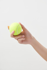 테니스 공을 들고 있는 여자의 손