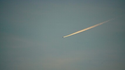 夕方の空に映る飛行機雲