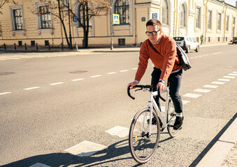 A young man riding a bicycle to work. Ecological transport for the city.
