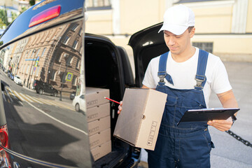 The driver is a courier delivering boxes by car to the customer's order address. The employee of the courier company is dressed in a uniform for convenient work.