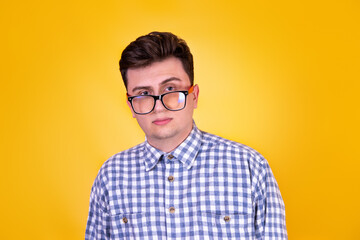 Obraz premium A handsome guy in glasses on a yellow background