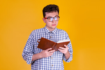 A handsome guy with a book on a yellow background